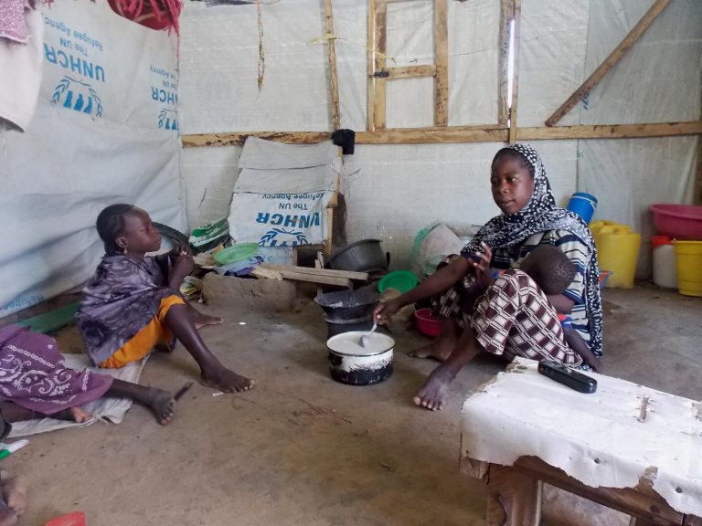 S and her children waiting for food in the camp